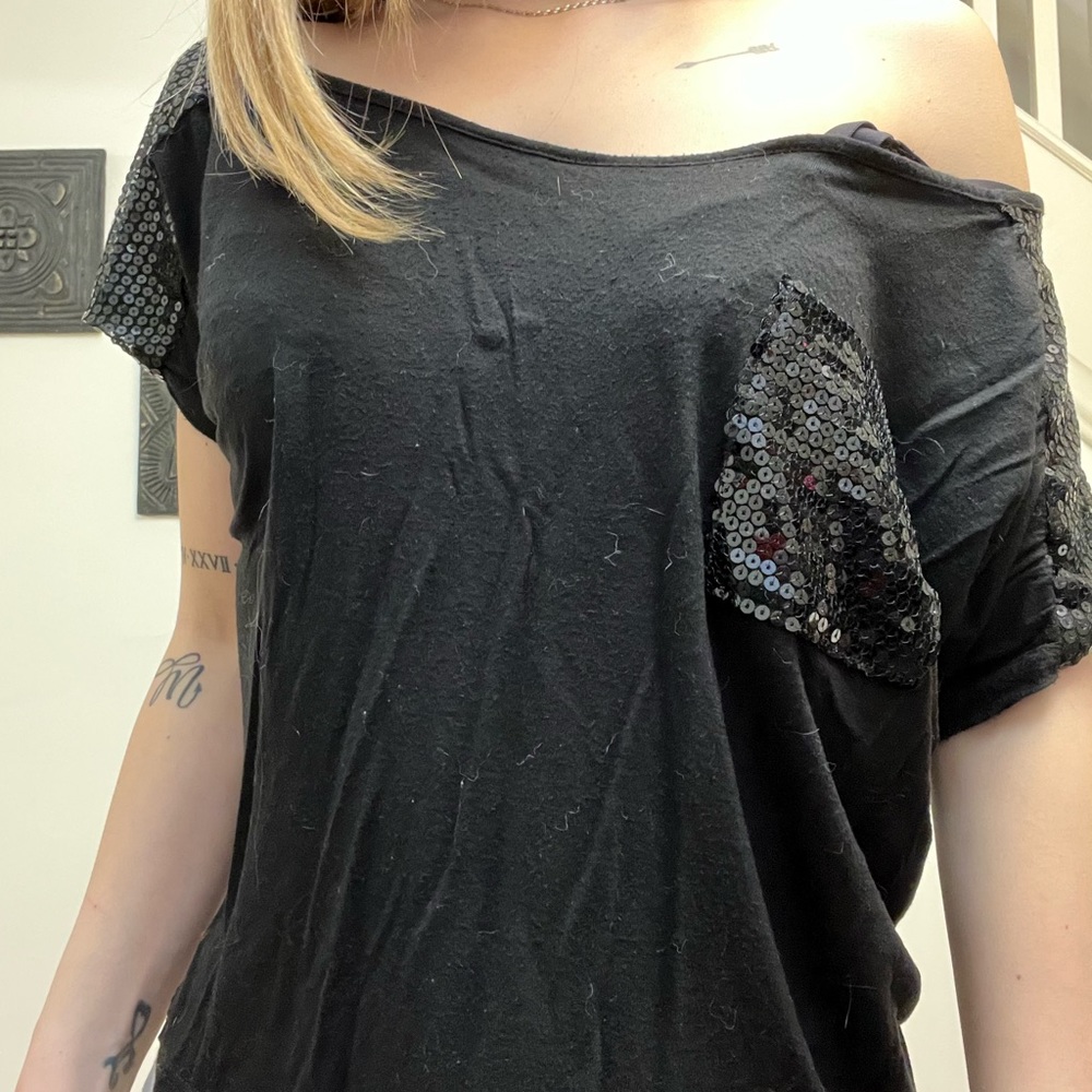 Black flowy t shirt. Can be off the shoulder. Sparkly shoulders and front pocket